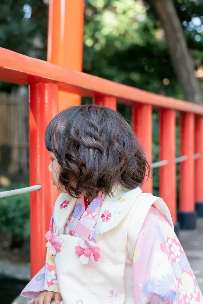 朱塗りの欄干と池を背に立つ、被布姿の3歳の女の子の横顔（六所神社の七五三出張撮影）
