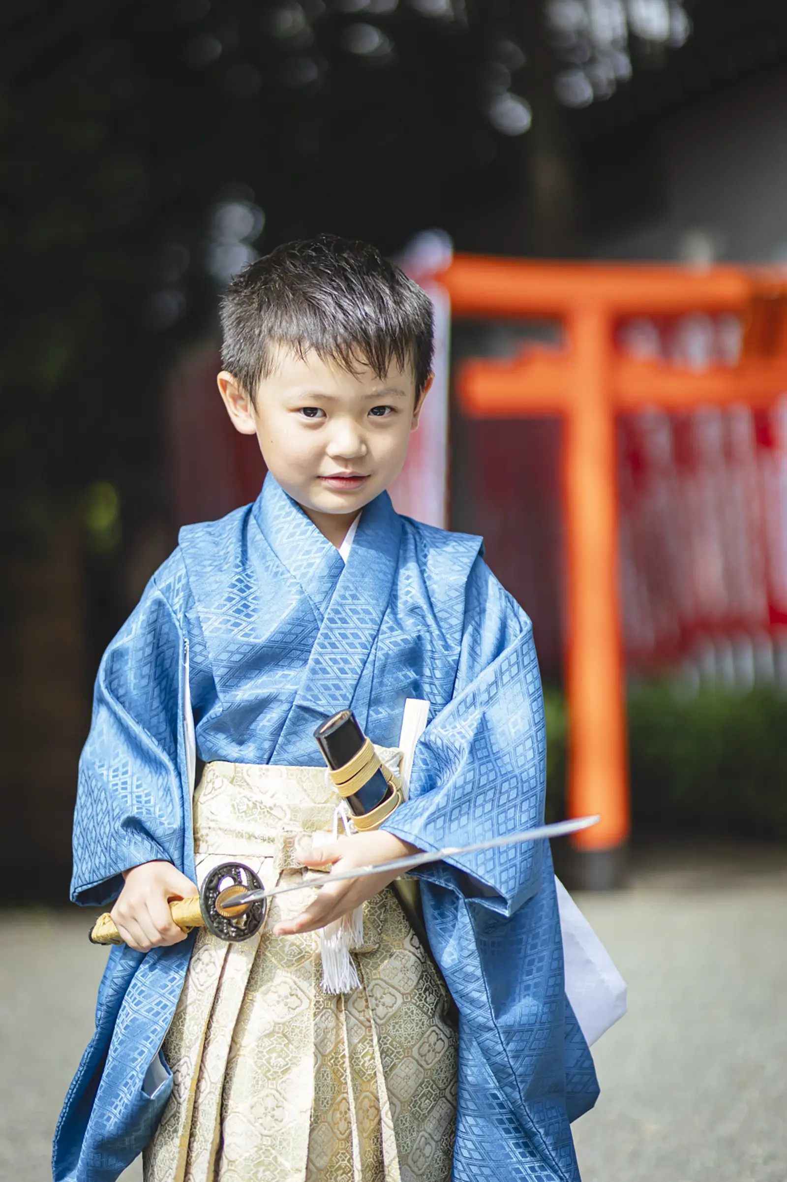 朱の鳥居を背にして正面を見る5歳の男の子、青い羽織袴の七五三（六所神社・大磯町）