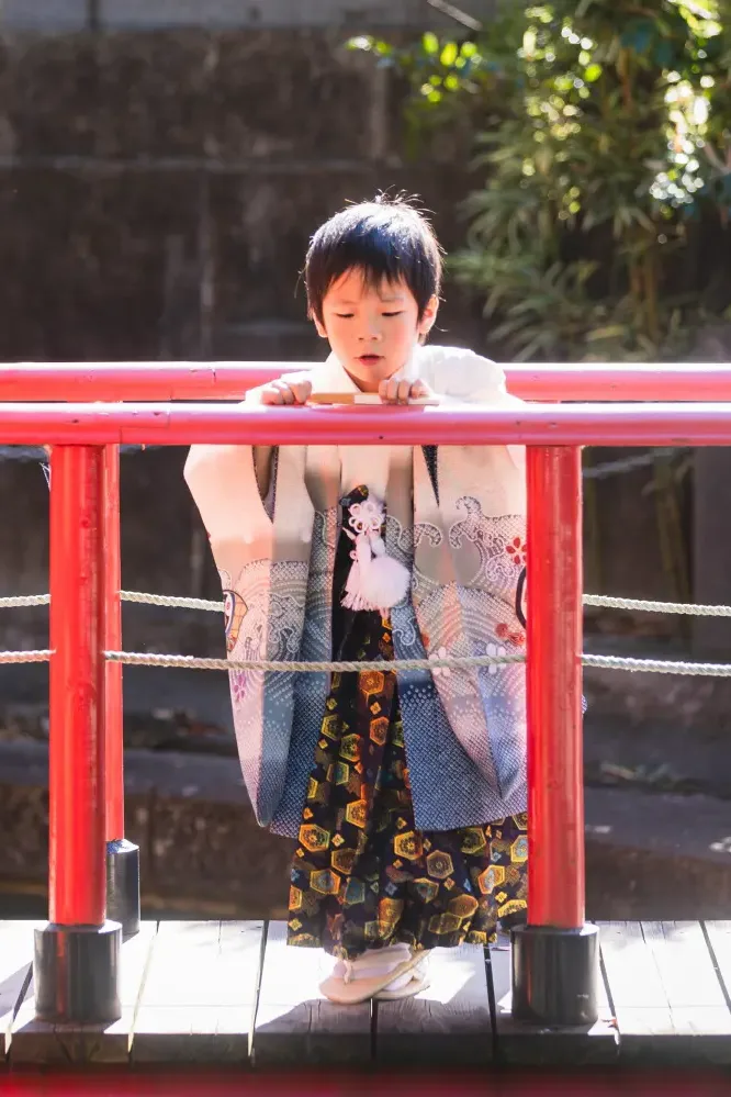 六所神社の朱塗りの欄干に手を置いてじっと見下ろす5歳の男の子、羽織袴の七五三撮影（大磯）