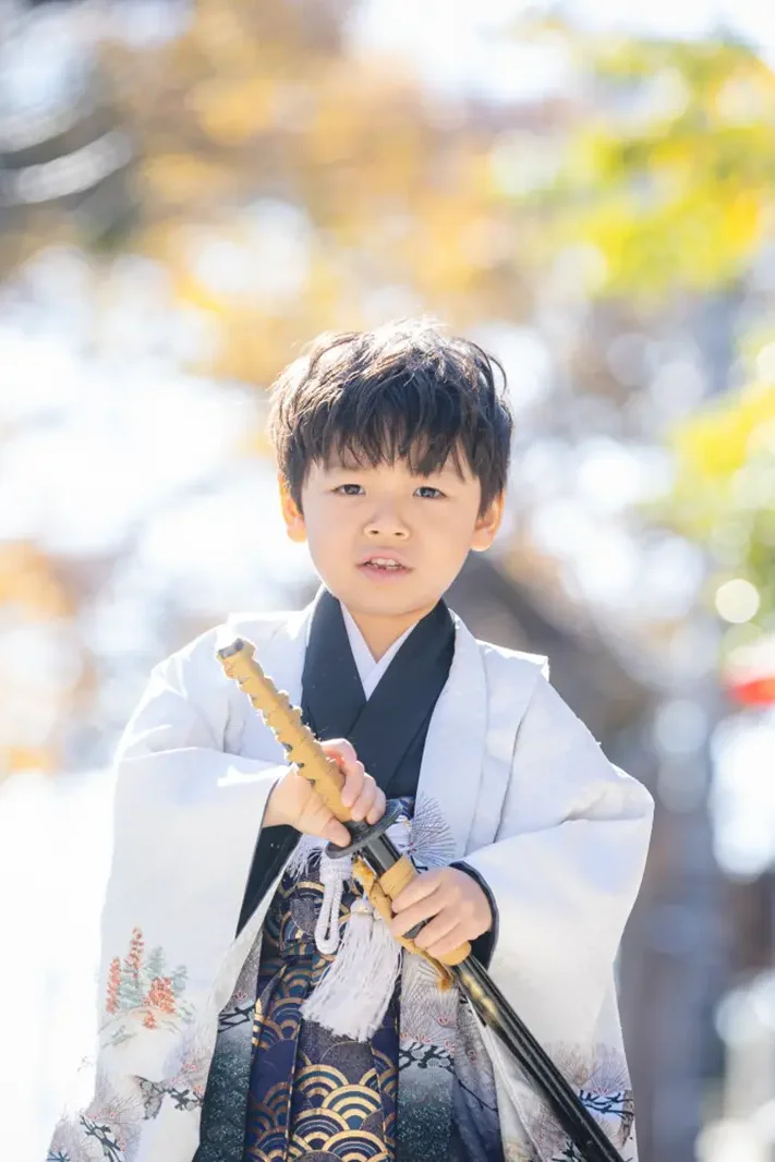 刀の形をした小物を両手で構える5歳の男の子、羽織袴姿の七五三（六所神社・大磯）