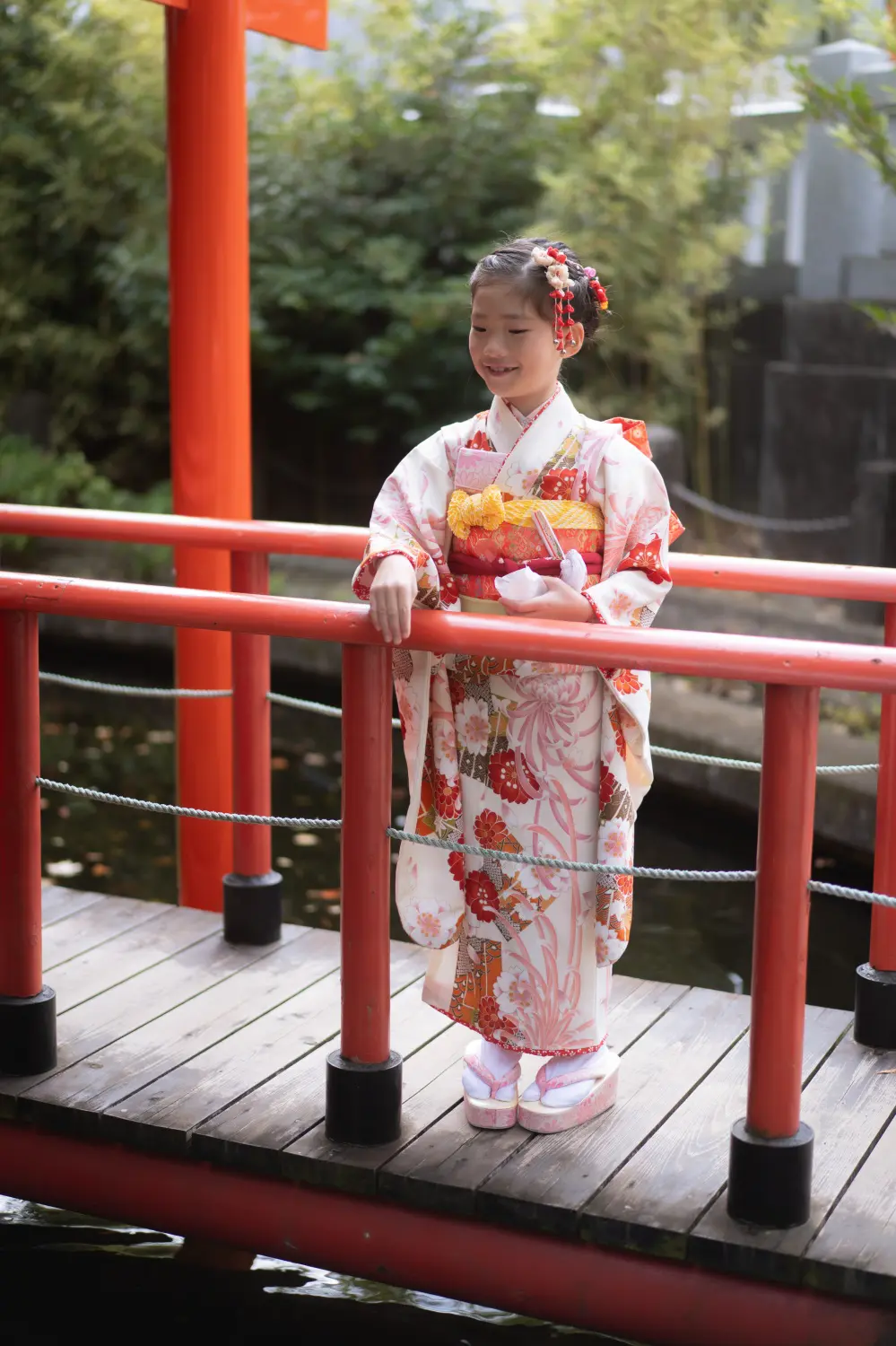 朱の欄干の太鼓橋に立つ7歳の女の子の全身、四つ身姿の七五三（六所神社・神奈川県大磯町）