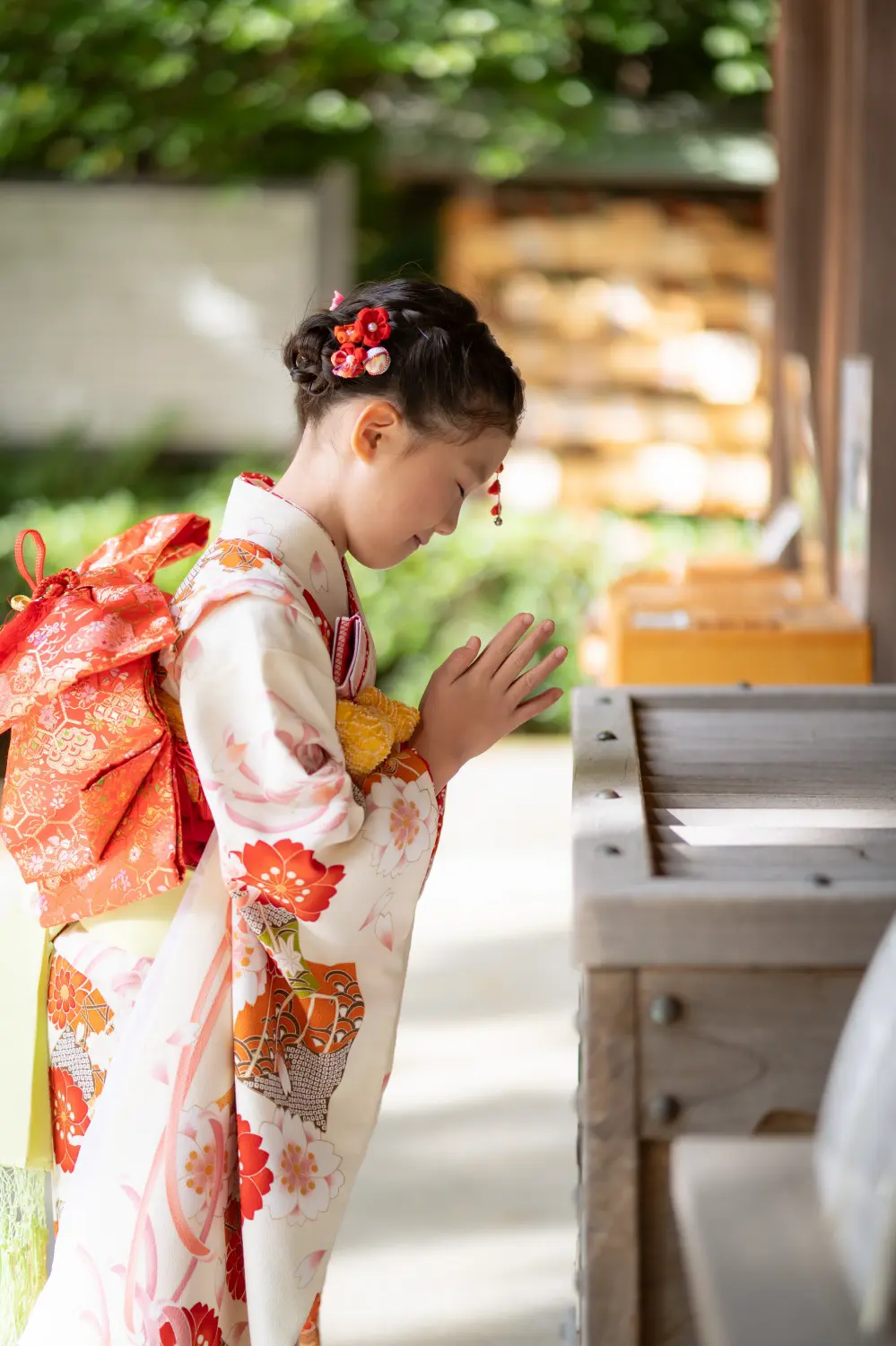六所神社の手水舎で目を閉じて手を合わせる7歳の女の子、四つ身姿の七五三（神奈川県大磯町）
