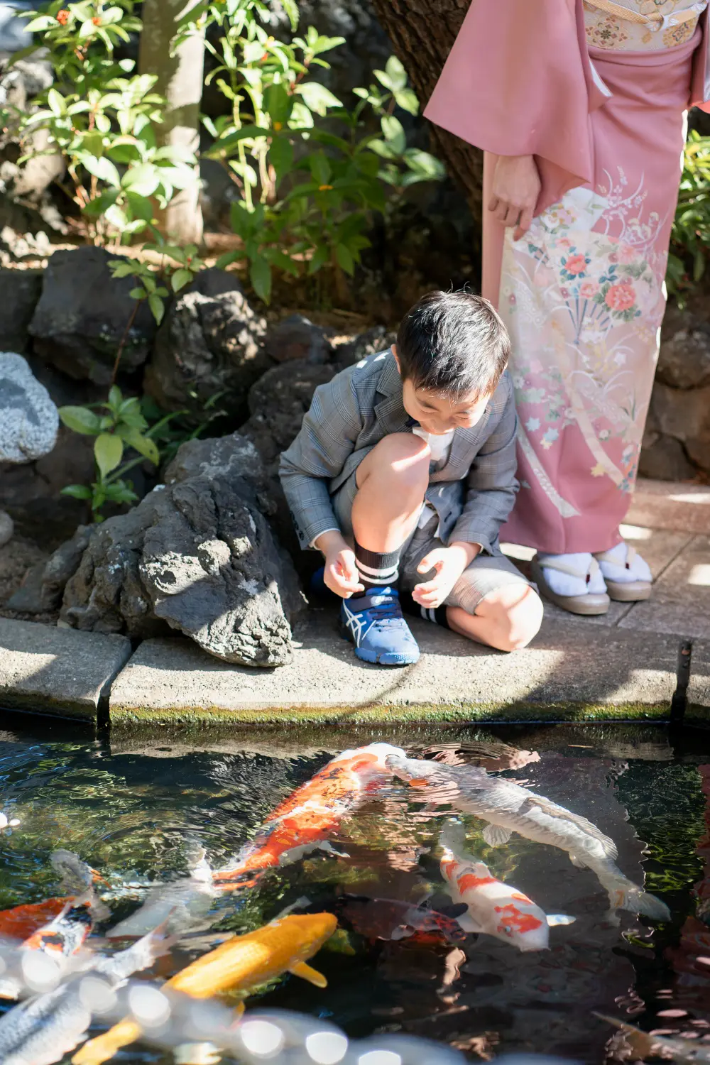 六所神社の境内の池で錦鯉をのぞきこむ兄と、そばに立つ訪問着の母（大磯・七五三）