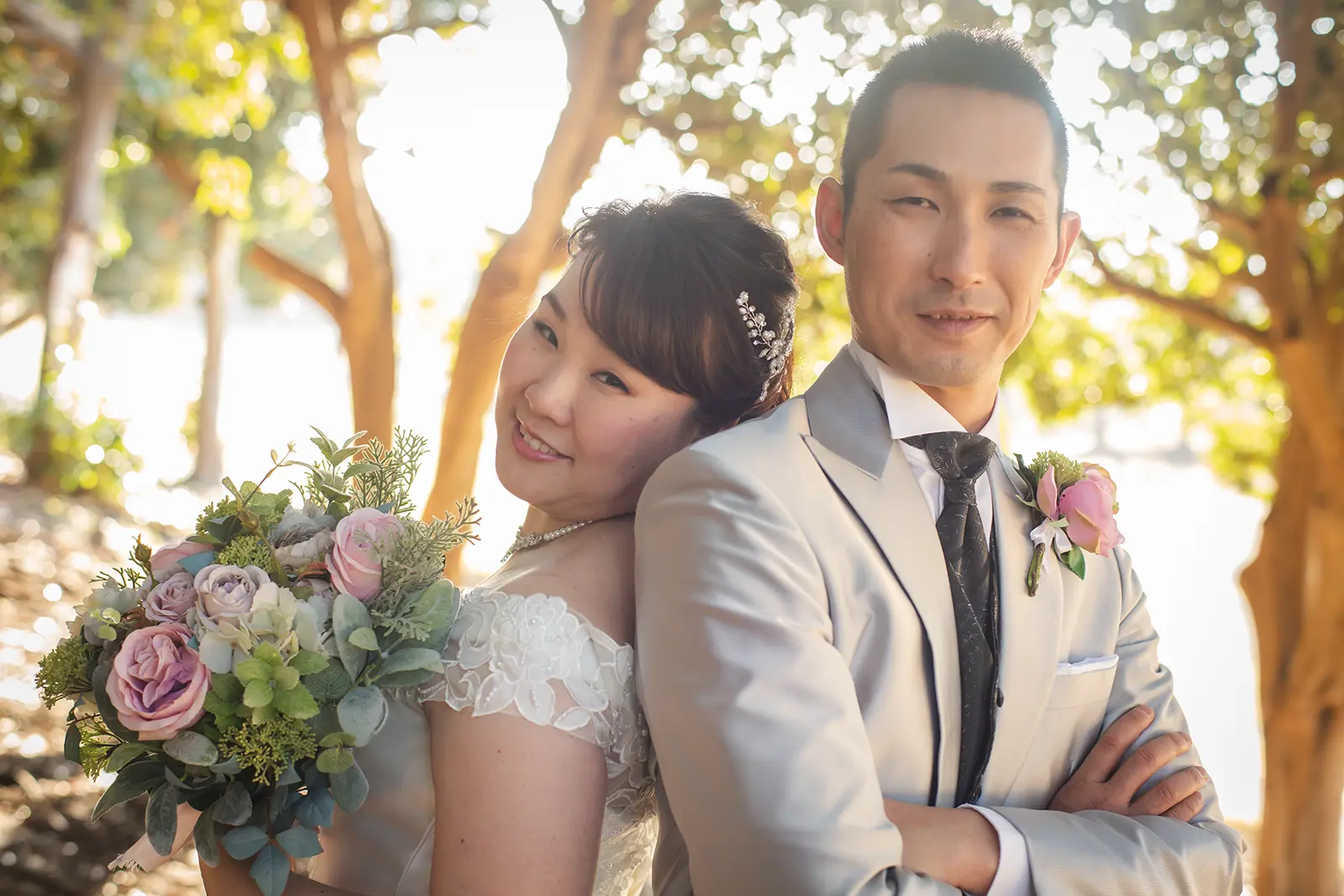 木漏れ日の中で寄り添う新郎新婦のポートレート写真