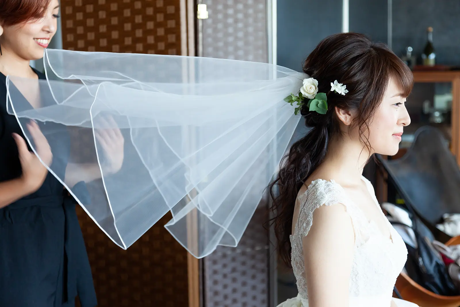 ベールを整えてもらう新婦の横顔を写した支度中の写真