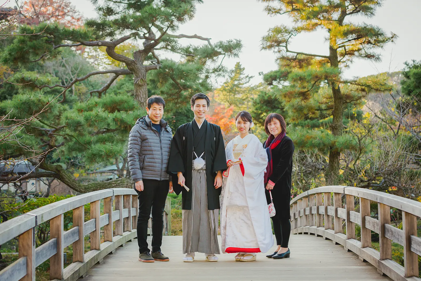 横浜の三溪園の橋の上で家族と一緒に撮影する和装姿の新郎新婦