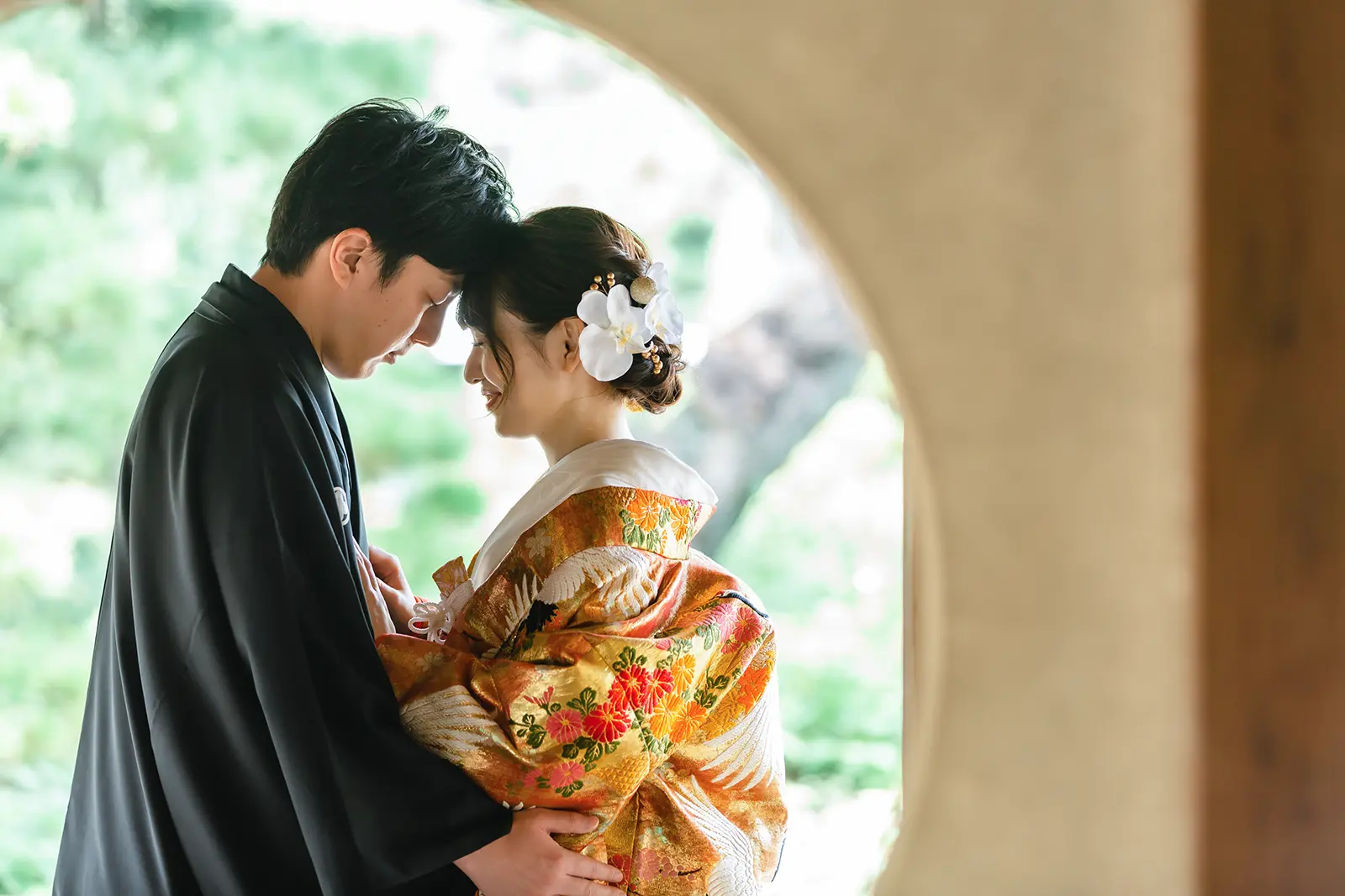 横浜の三溪園で丸窓の前に寄り添う和装姿の新郎新婦のアップ写真