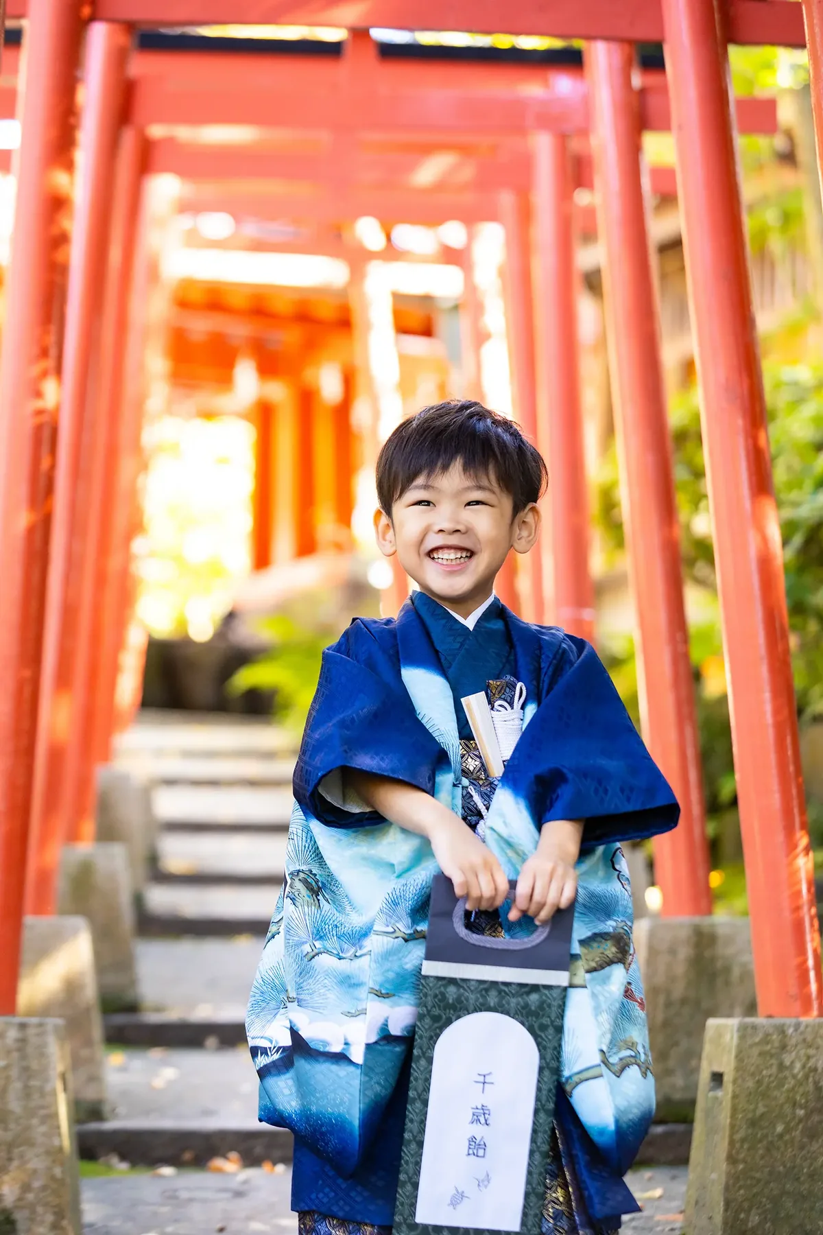 七五三 5歳の男の子 青の羽織袴で千歳飴を持つ姿｜フォトジェリッシュ