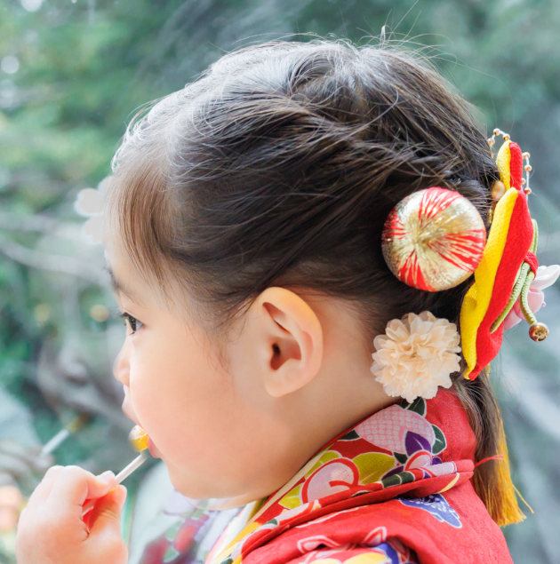 七五三で3歳の女の子の髪型のアップ。ミディアムの髪をまとめ、大きなリボン飾りをつけた