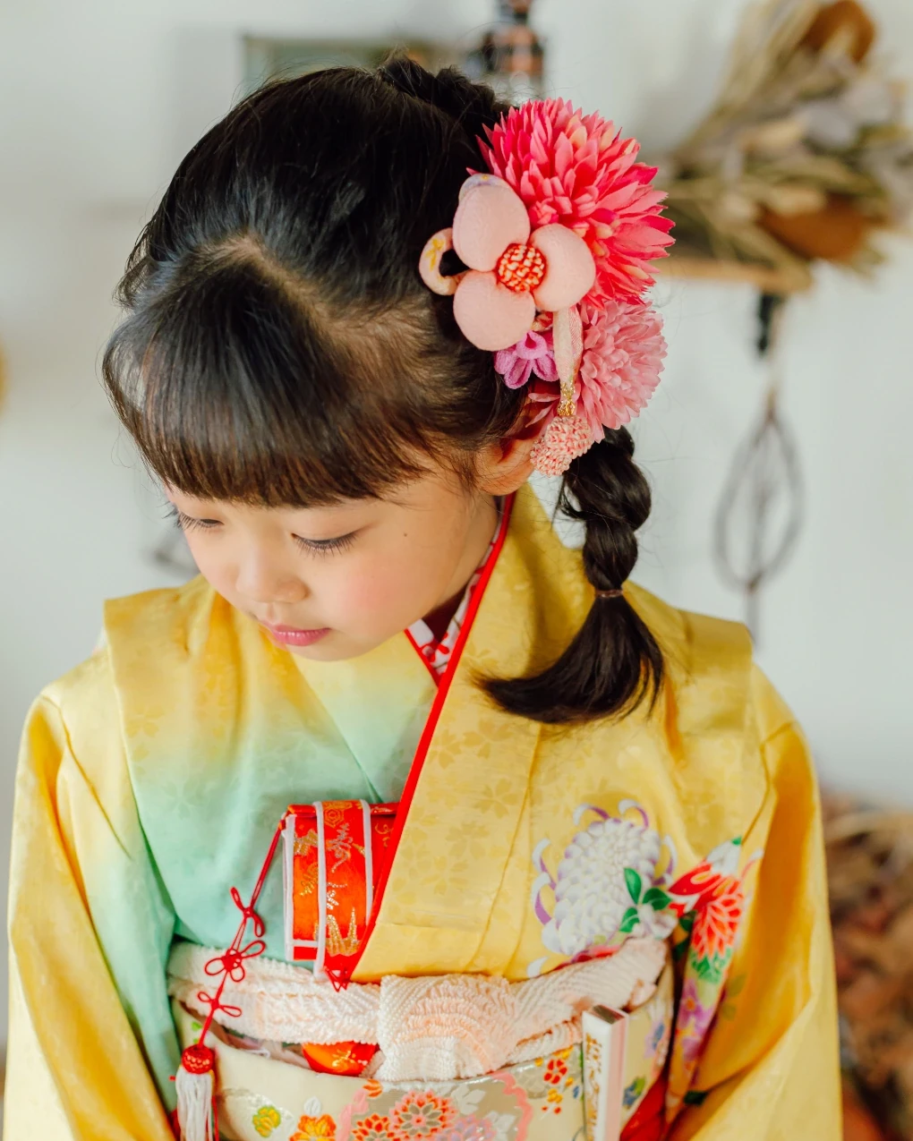 前髪ありの七五三7歳。サイドの三つ編みに、ピンクの大輪の花飾り