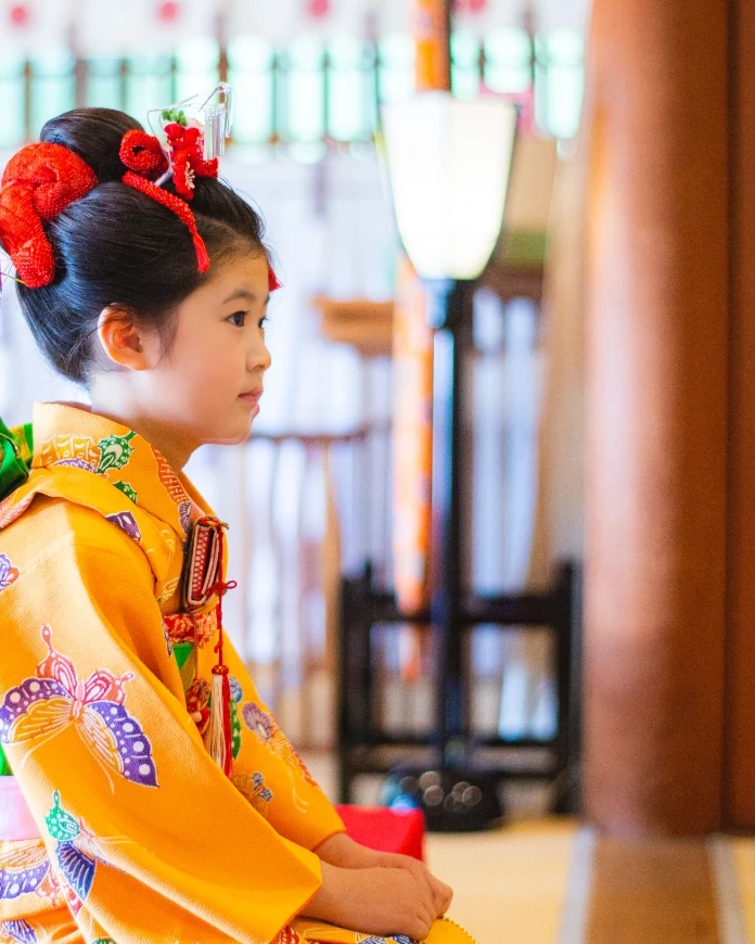 ご祈祷中の7歳の女の子の横顔。赤い鹿の子の日本髪風アップ