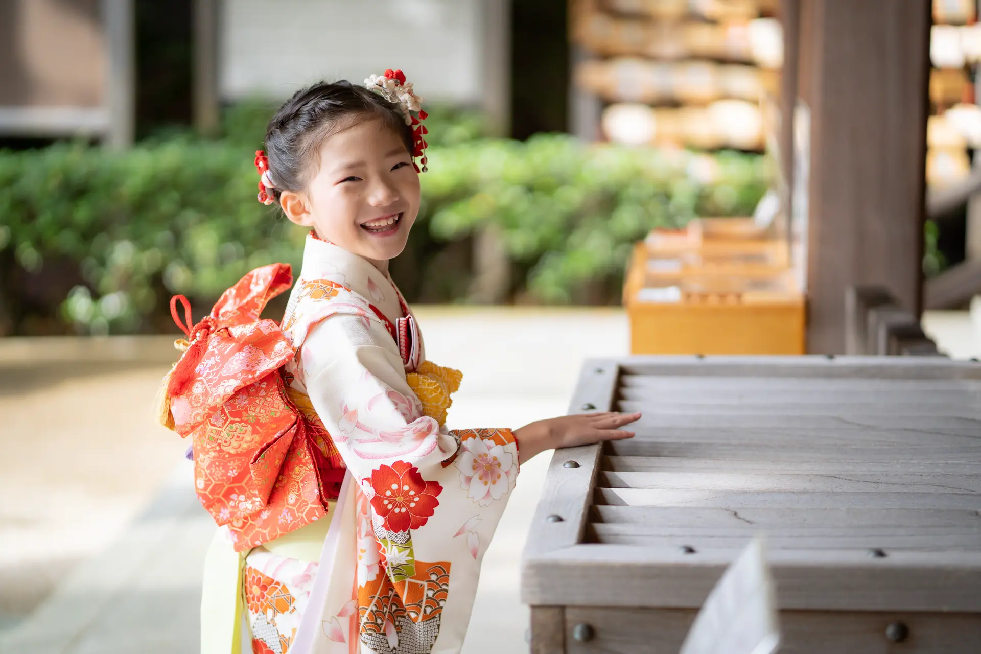 六所神社の境内で振り返って笑う7歳の女の子｜七五三スナップ｜フォトジェリッシュ