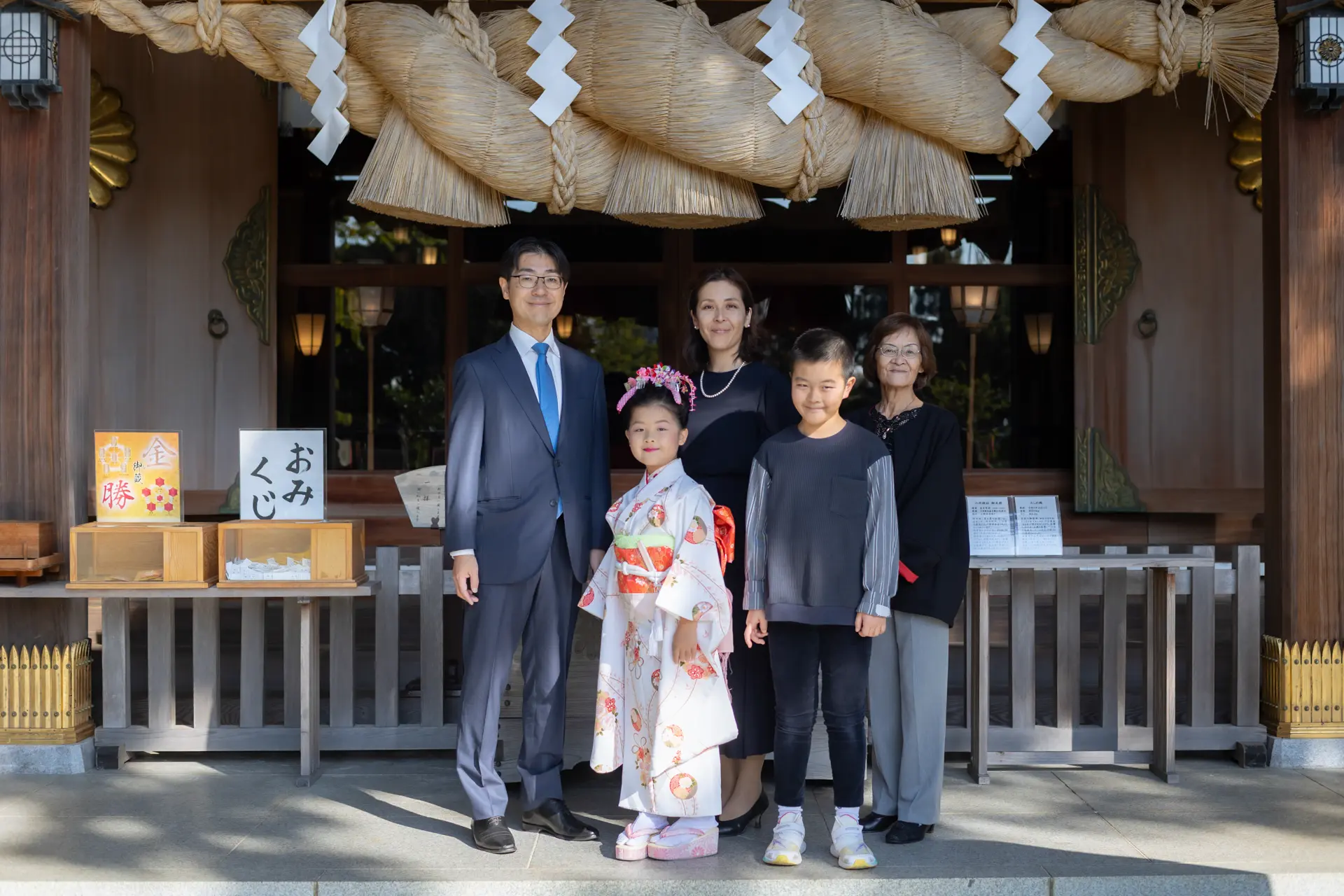 六所神社の大注連縄の下に三世代で並ぶ七五三のご家族｜フォトジェリッシュ