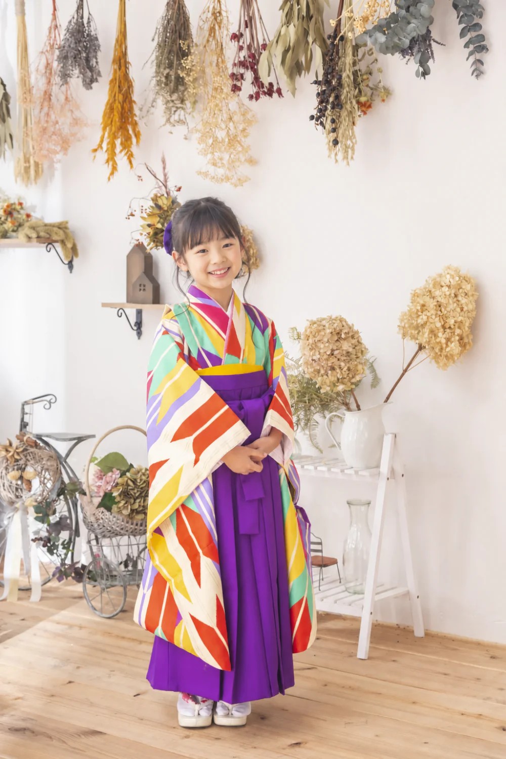 小学校卒業袴のスタジオ前撮り。矢絣柄の二尺袖×紫袴の全身カット