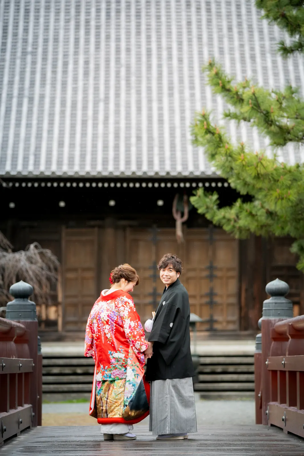 称名寺の金堂の前で向かい合う、赤い色打掛の花嫁と紋付袴の新郎