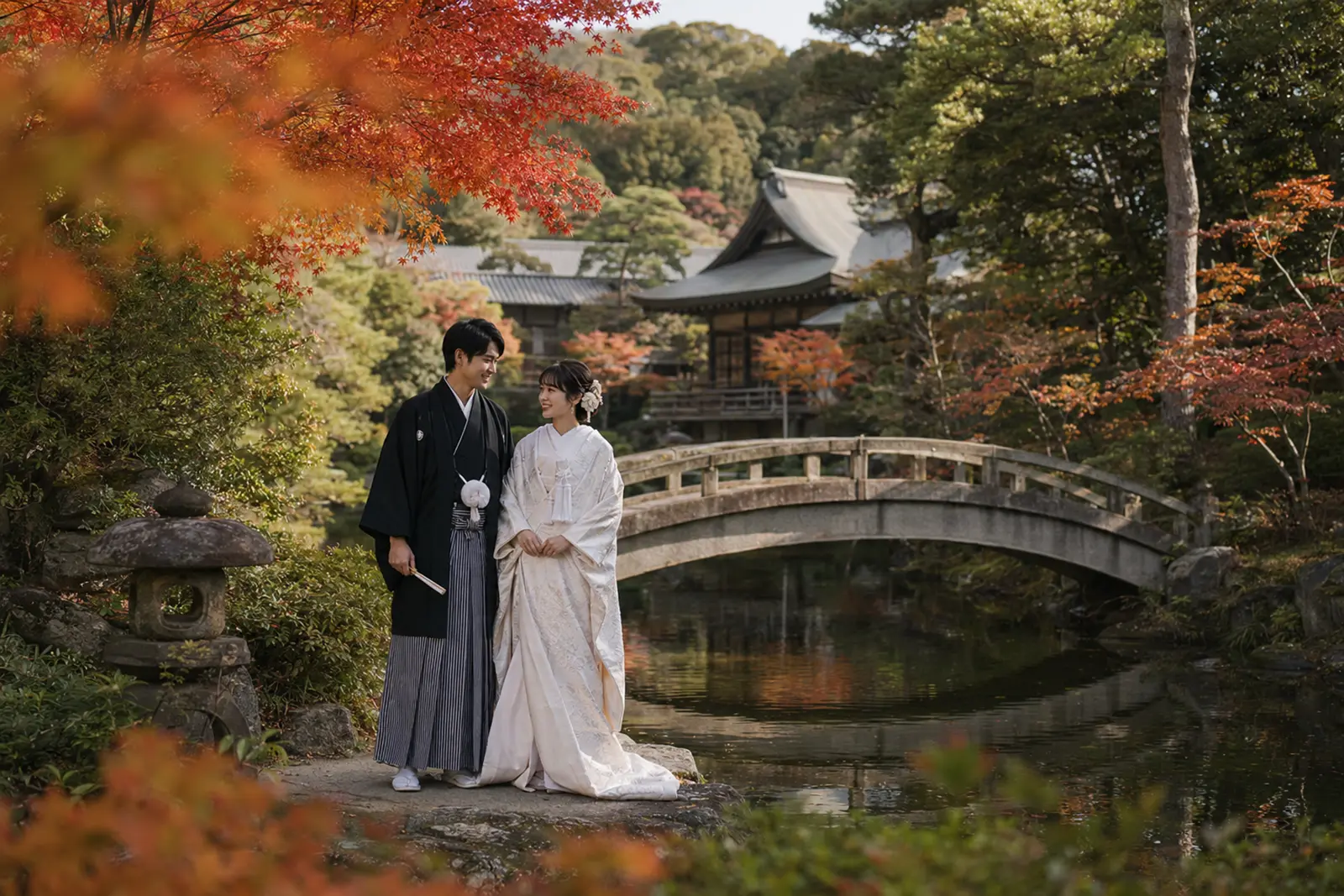 称名寺のような池と橋のある静かな紅葉ロケーションで和装の新郎新婦が立つ写真
