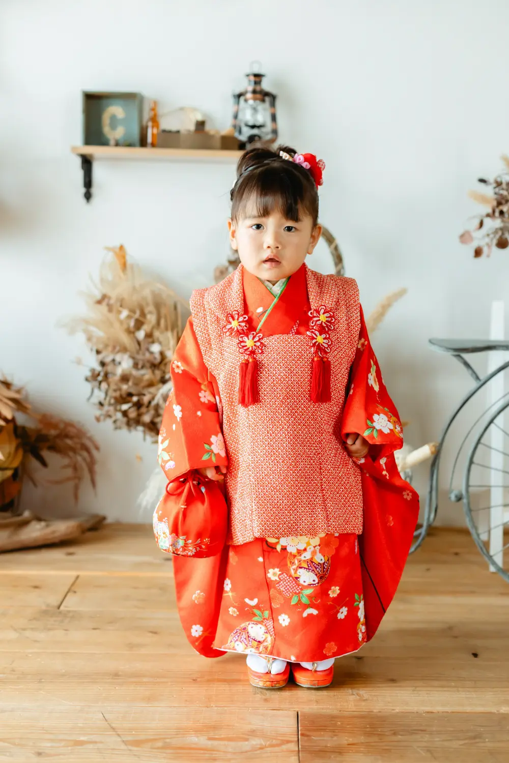 朱赤の被布と桜柄の着物で立つ3歳の女の子の全身、七五三スタジオ撮影（横浜）