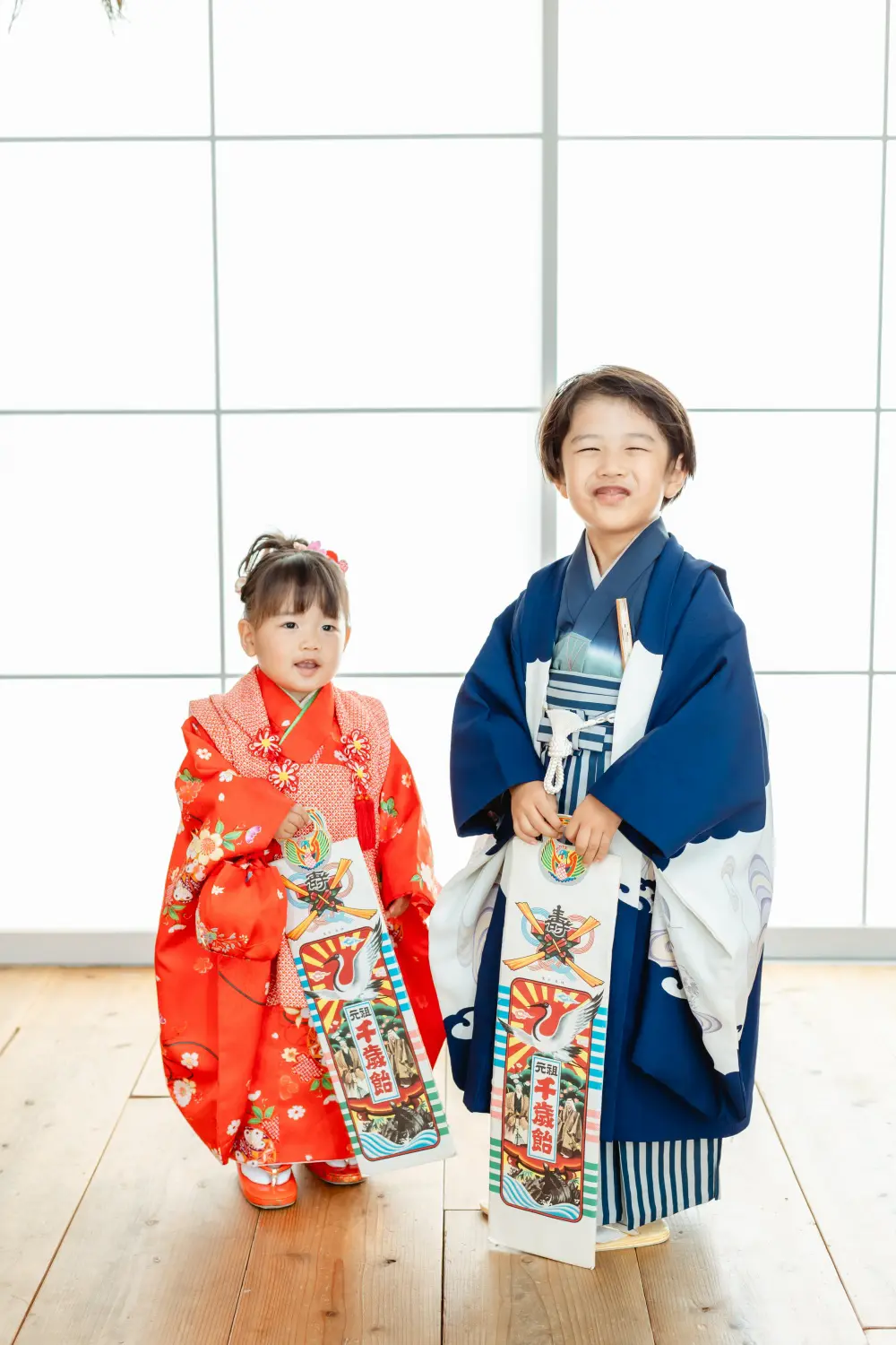 千歳飴の袋を持って並ぶ和装のきょうだい、5歳の兄と3歳の妹の七五三（横浜のスタジオ）