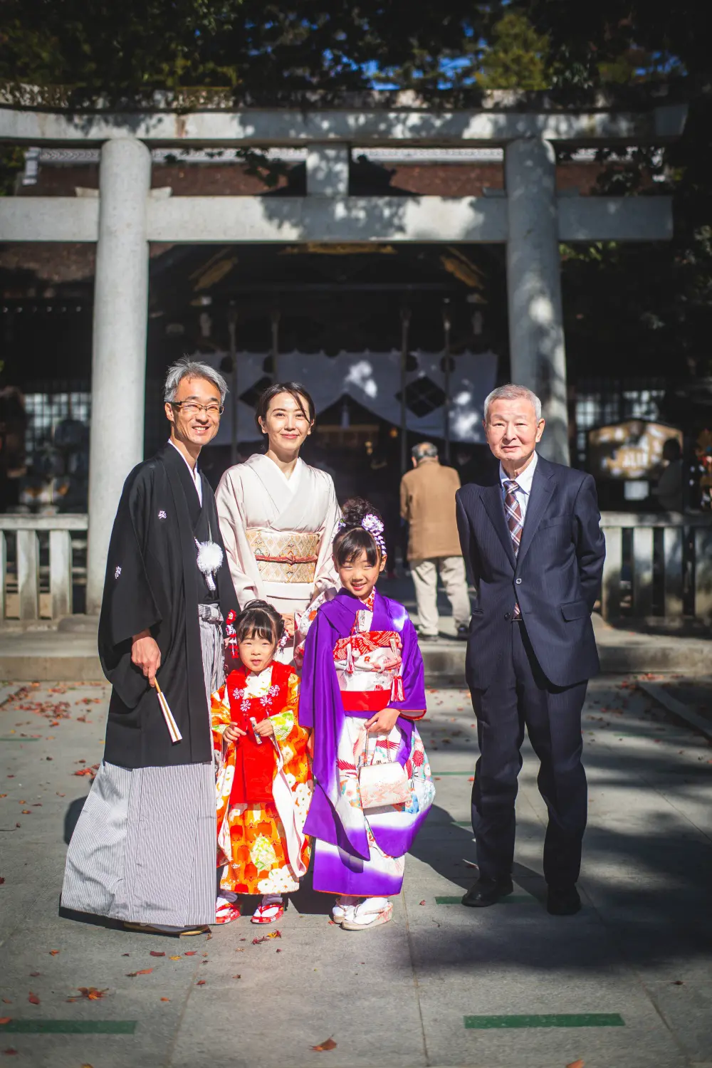 鳥居前に並ぶ三世代の家族と7歳・3歳の姉妹、七五三の記念写真（武田神社・山梨）