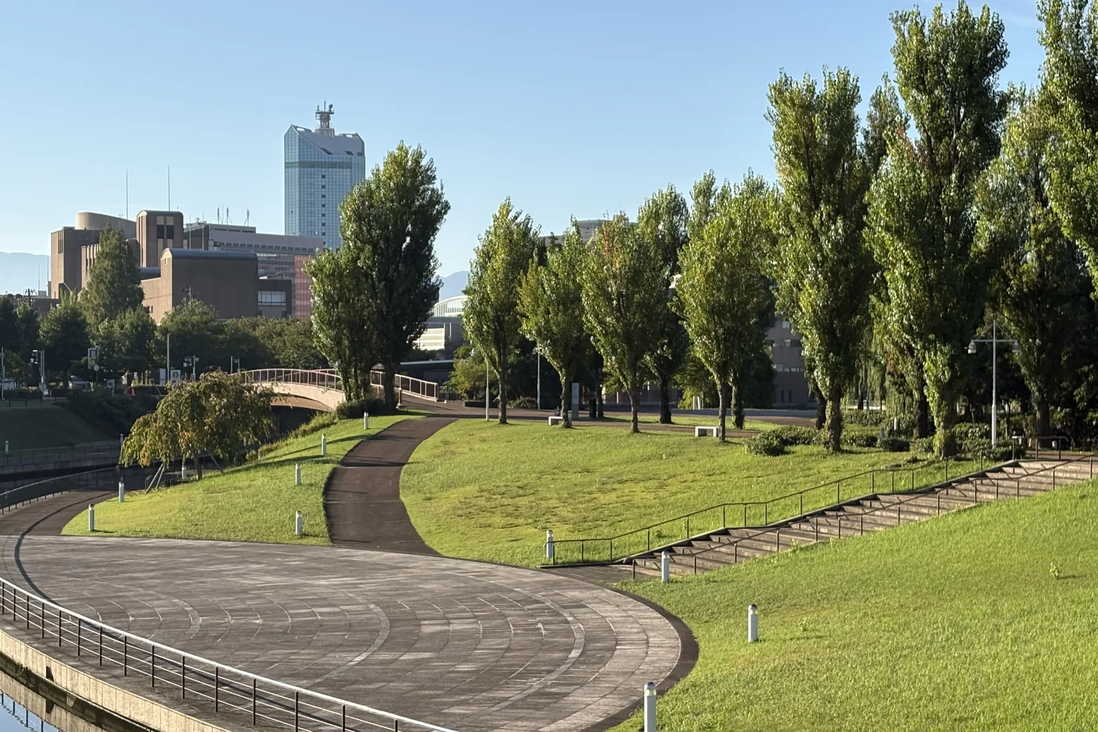 環水公園の曲線を描く芝生と運河、富山の街並み