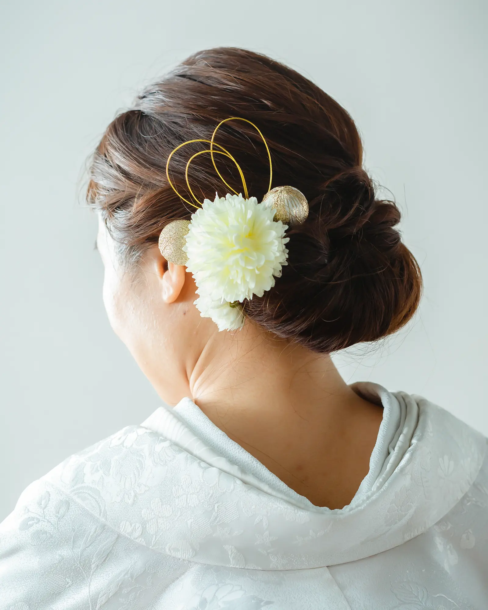 和装に合わせた複数の花飾りを使った華やかなアップスタイル