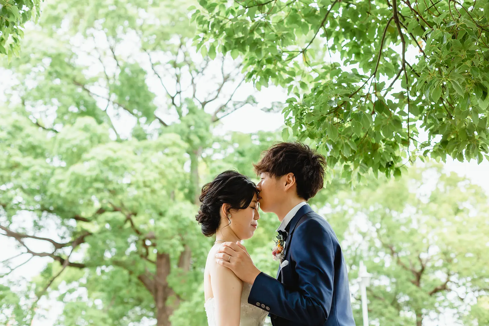 山下公園の緑の中で寄り添う洋装フォトウェディング