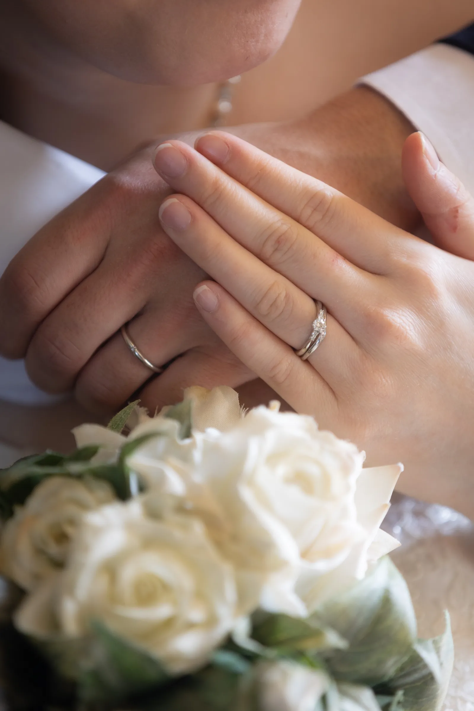ウェディングブーケと結婚指輪をあわせた手元のクローズアップ
