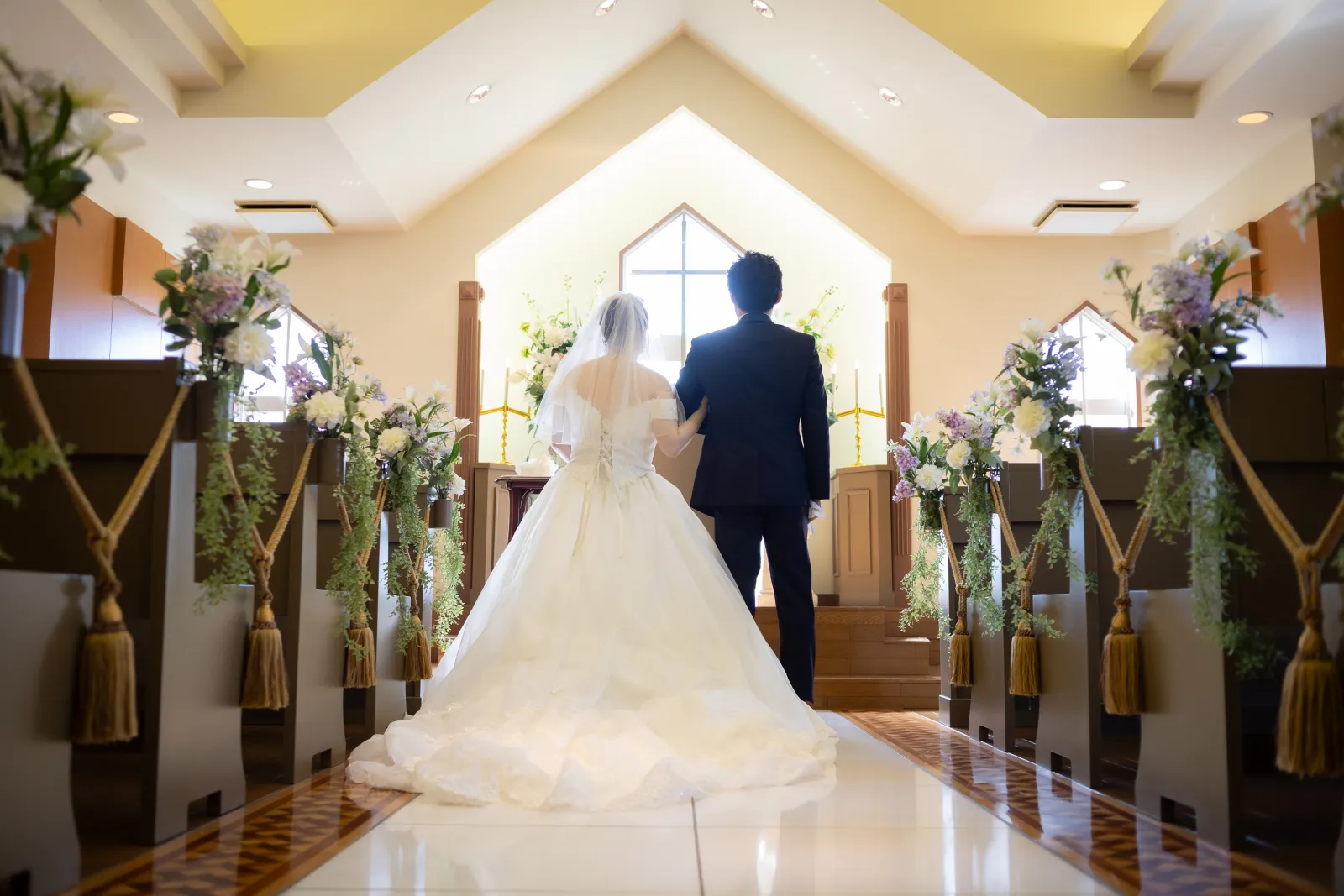 山手ヘレン記念教会の祭壇へ向かって進む新郎新婦の後ろ姿