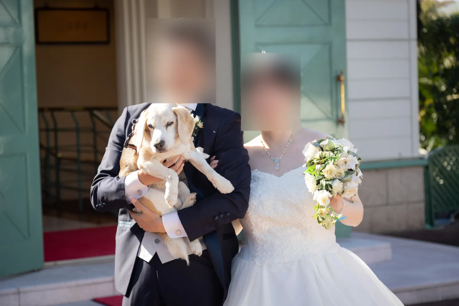 ウェディングドレスとタキシード姿で愛犬ジンくんを抱く新郎新婦