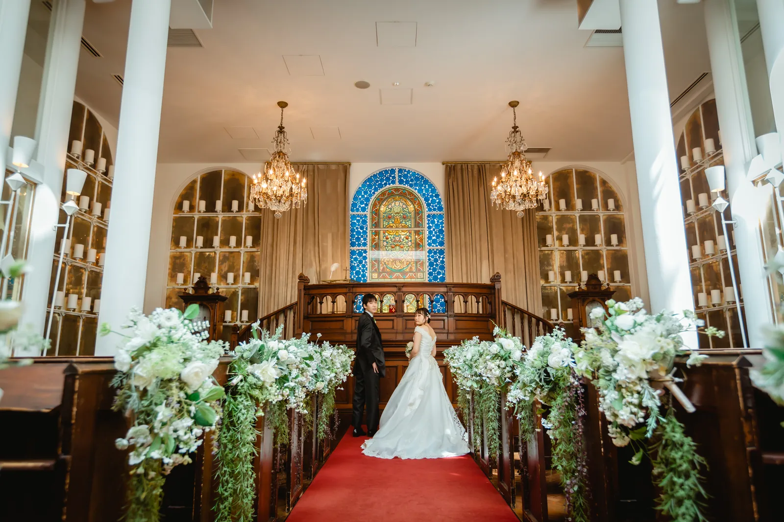 ラ・バンク・ド・ロアの祭壇前。ステンドグラスとシャンデリアを背にした新郎新婦