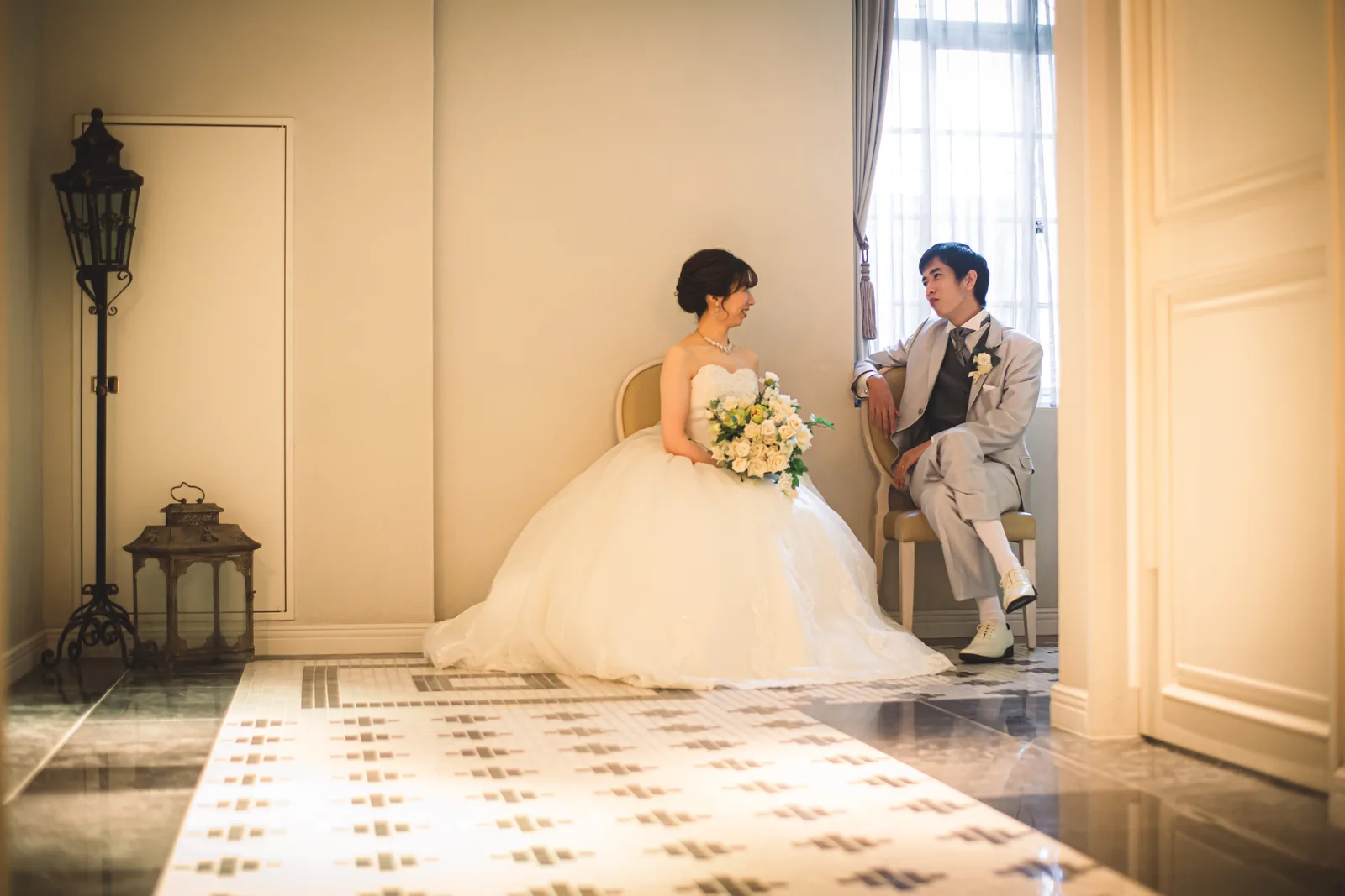 ラ・バンク・ド・ロアのタイル床の部屋で座って見つめ合う新郎新婦