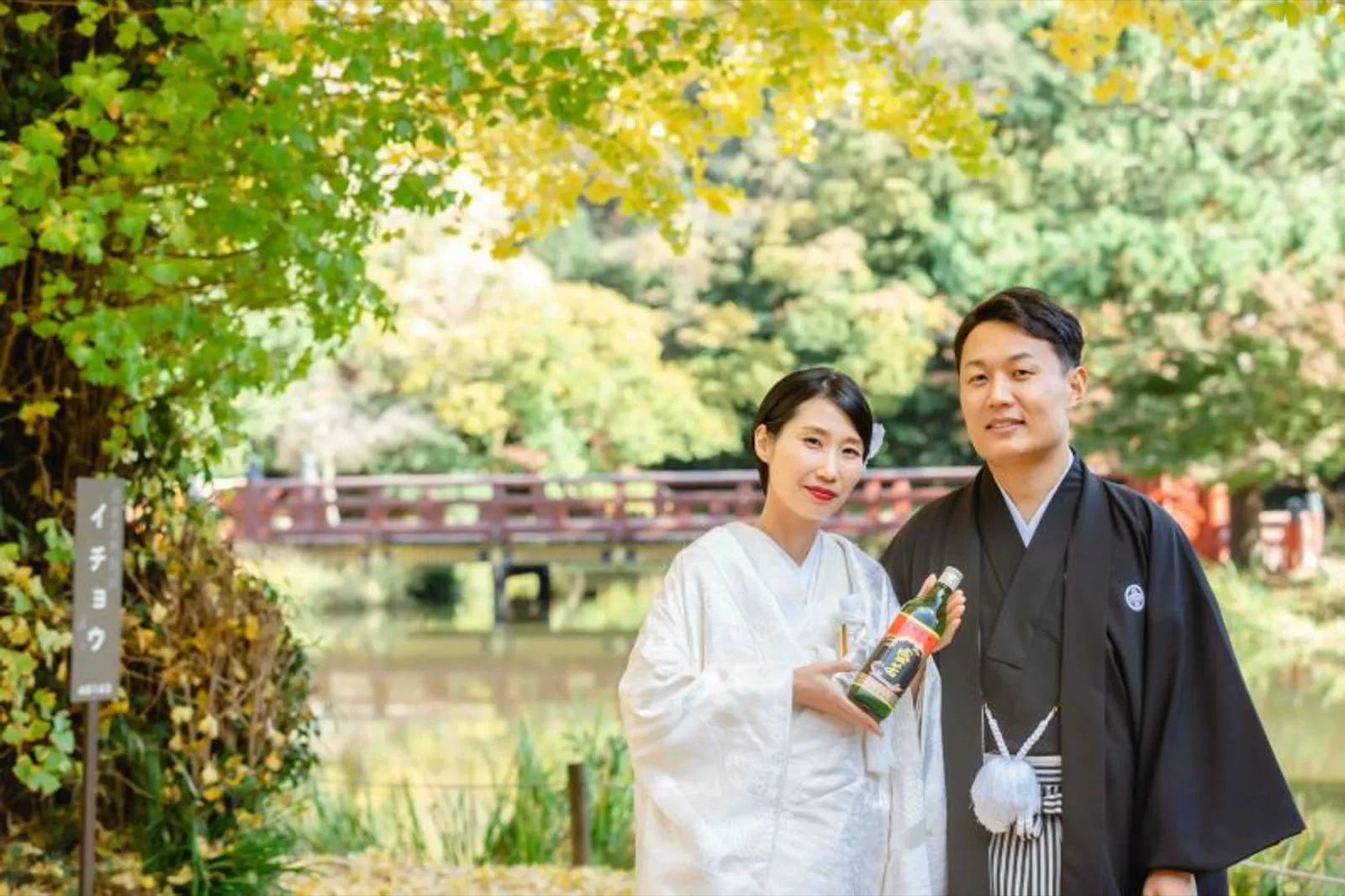 横浜・称名寺の池と反り橋、色づくイチョウを背景に立つ白無垢の花嫁と黒紋付の新郎｜和装ロケーションフォトウェディング