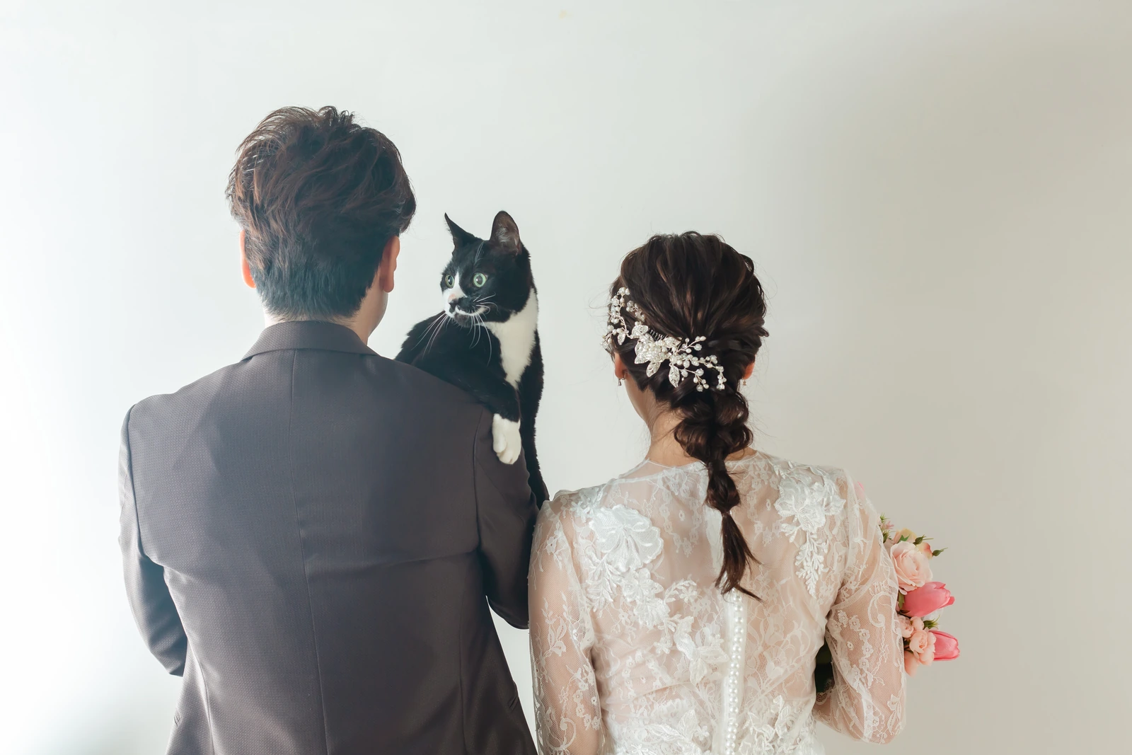 髪飾りとレースのドレスが美しい花嫁のバックショットと黒猫