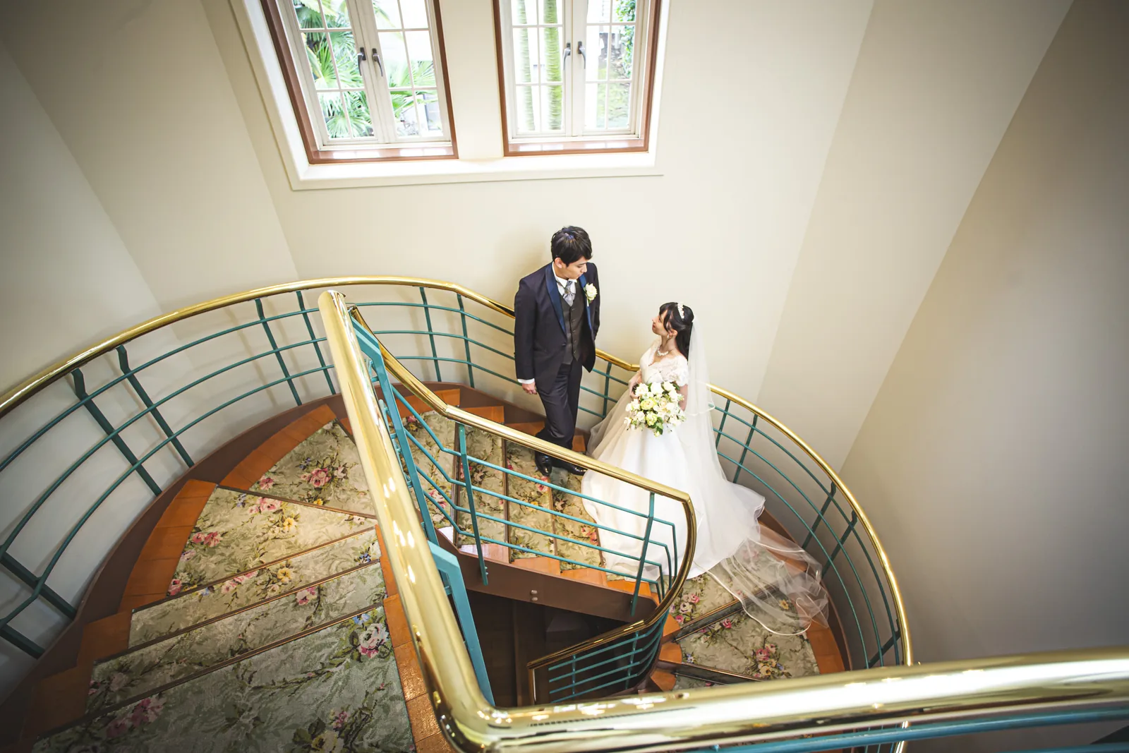 らせん階段を上から見下ろして撮影した新郎新婦のウエディングフォト