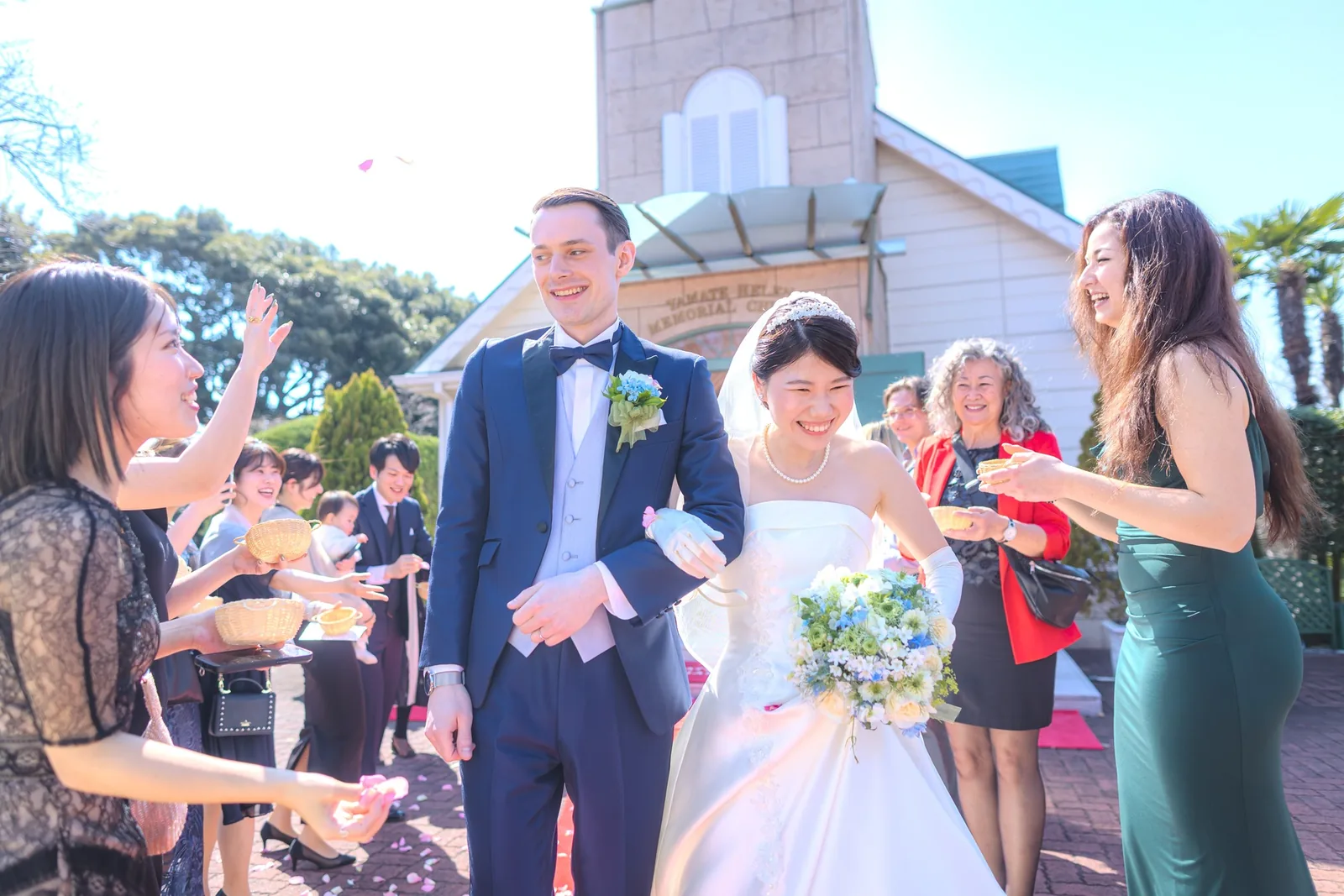 山手ヘレン記念教会の前でフラワーシャワーを浴びる新郎新婦