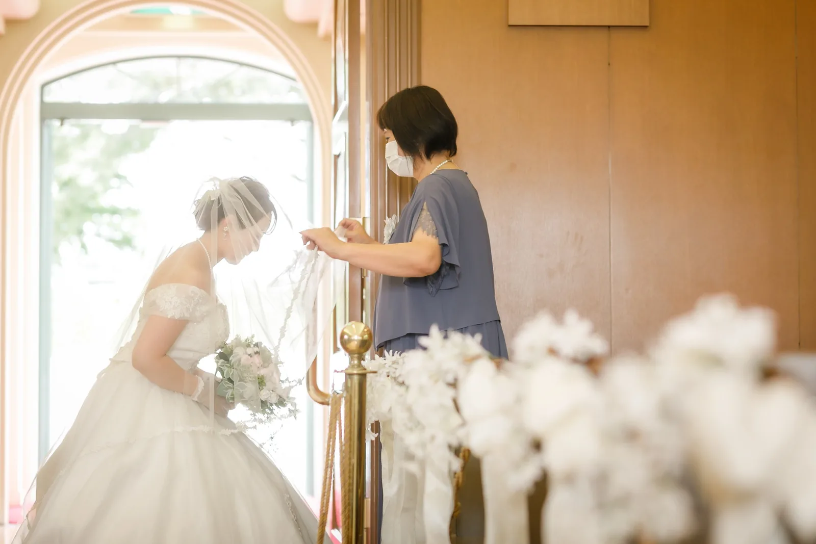 山手ヘレン記念教会の入口でベールを整えてもらう花嫁