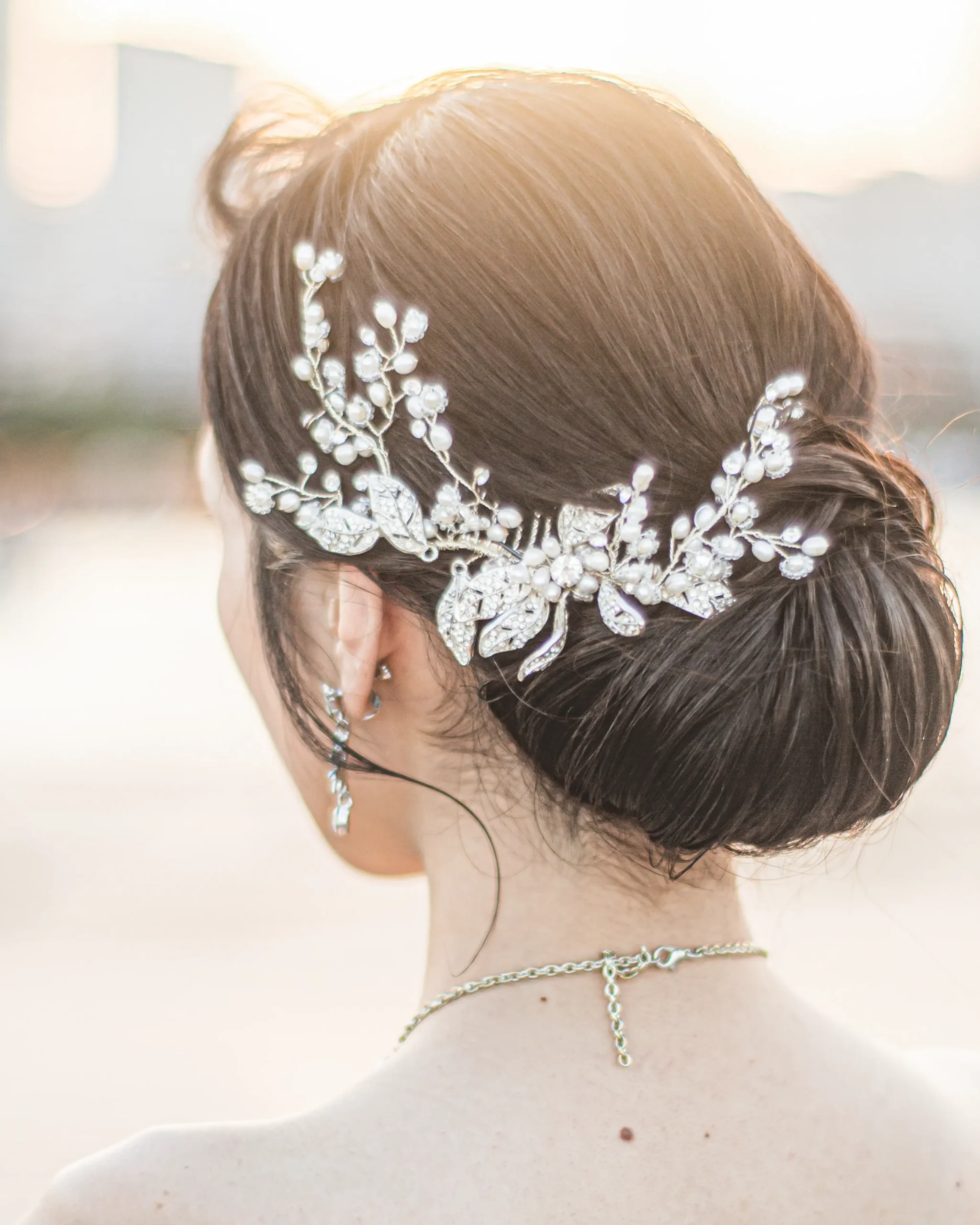 洋装のロングヘアを低めのシニヨンにまとめ、ビジューアクセサリーを合わせた花嫁ヘアスタイル