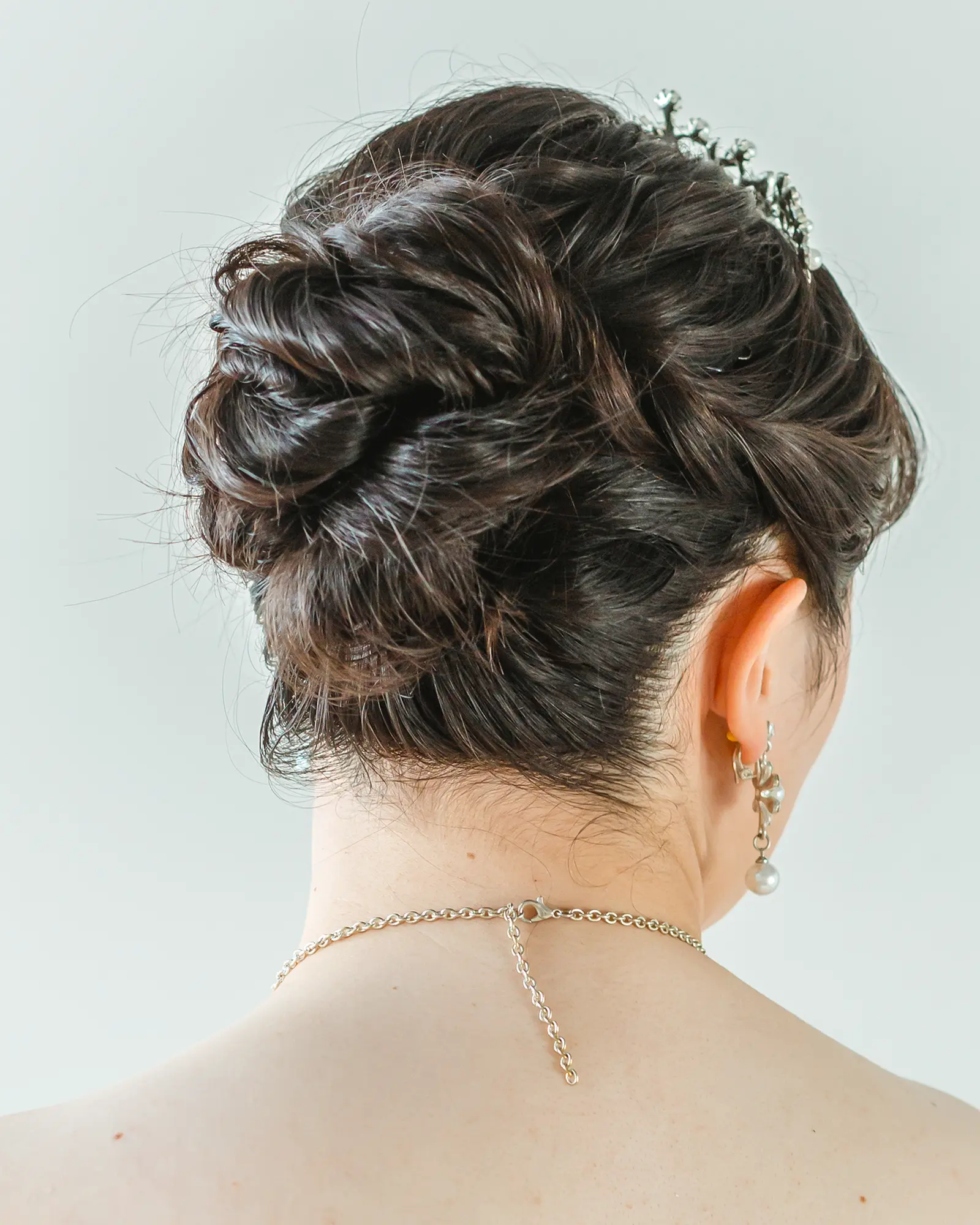 洋装のロングヘアをコンパクトにまとめたアップスタイルの花嫁ヘア