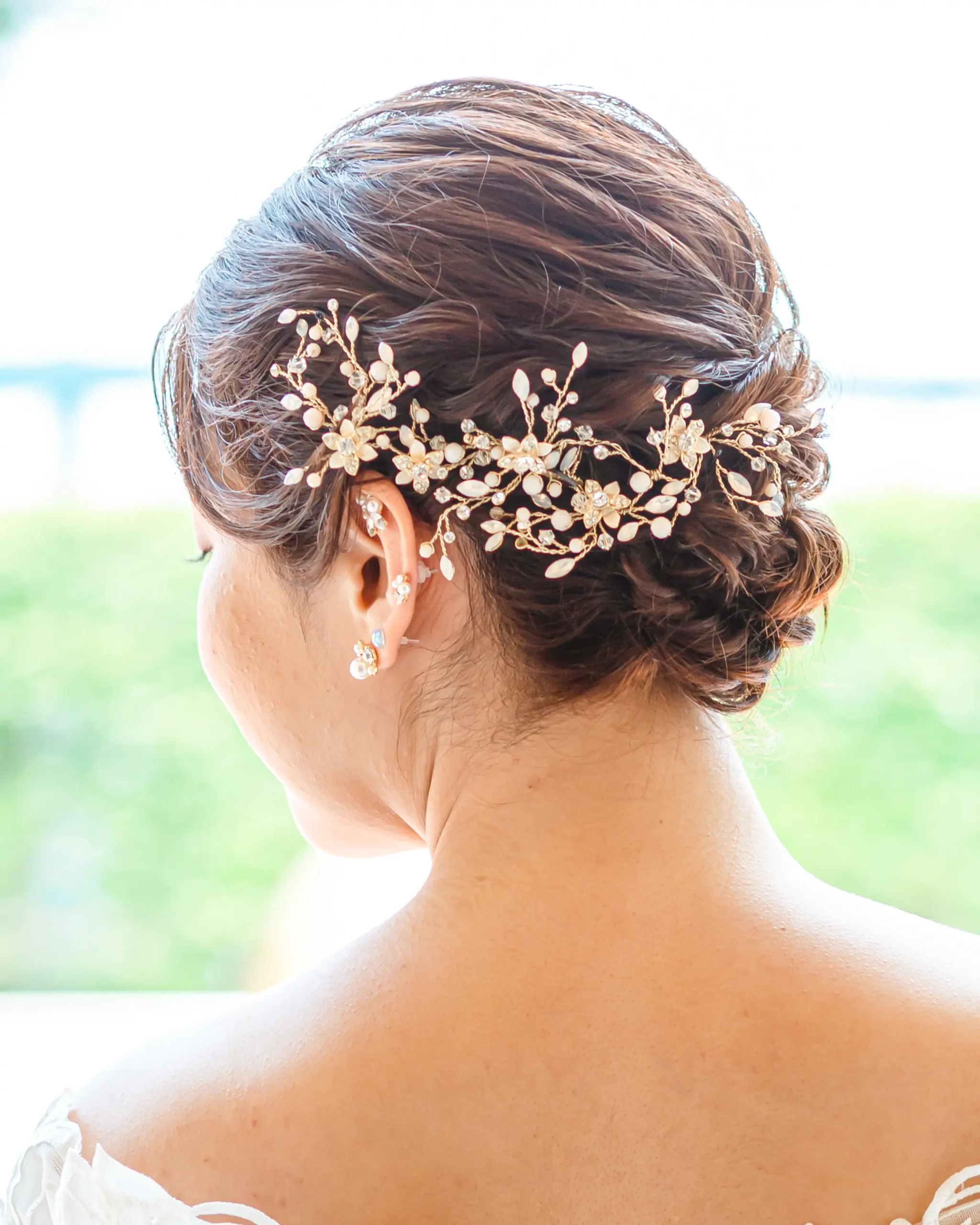 洋装のセミロングヘアをシニヨンにまとめ、小枝風アクセサリーを合わせた花嫁ヘアスタイル