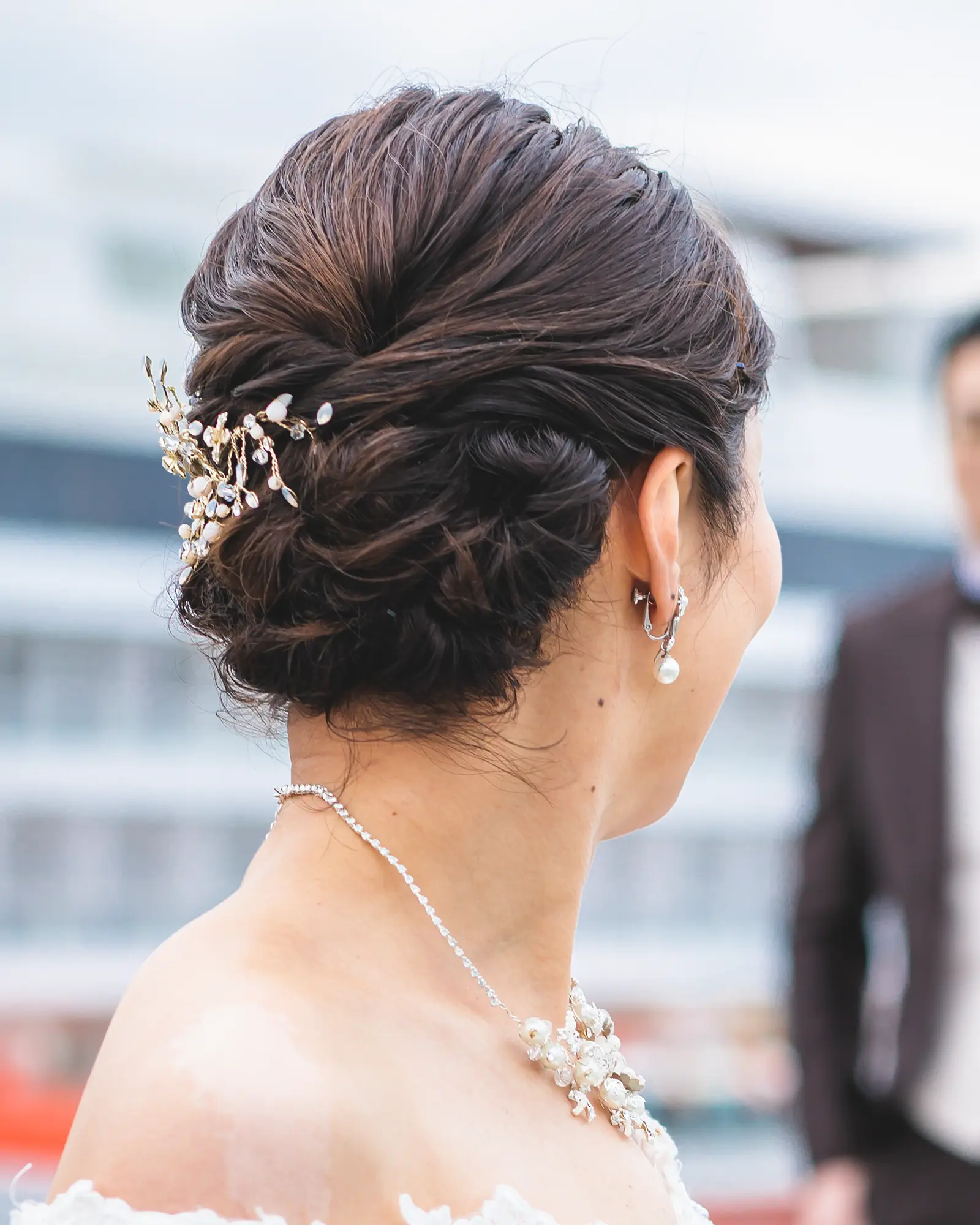 洋装のショートヘアを低めにまとめ、ビジューアクセサリーを合わせたヘアスタイル
