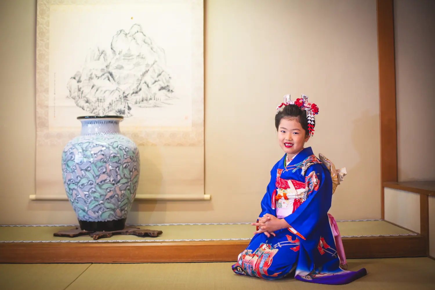 掛け軸と大壺のある座敷で正座して笑う7歳の女の子、四つ身の七五三（湯島天神・東京）