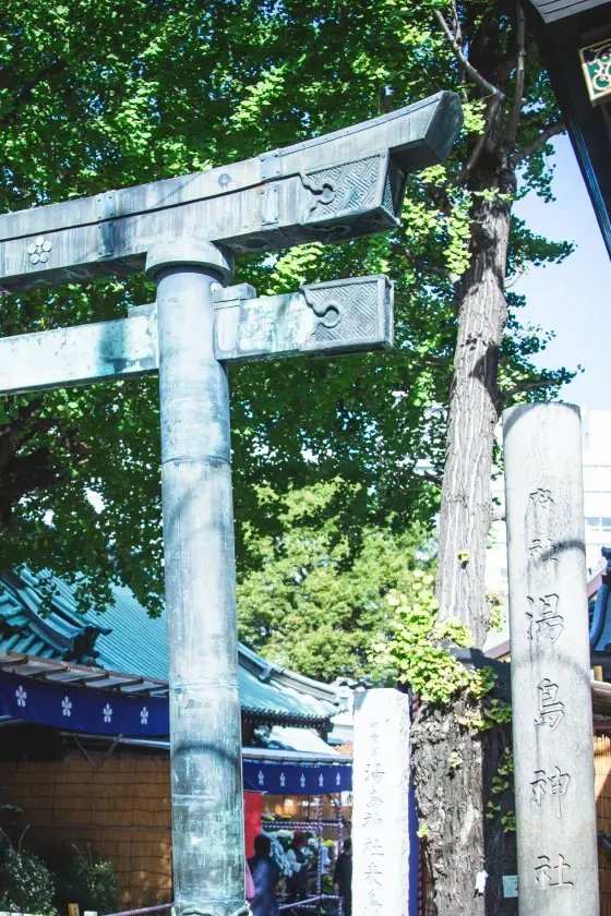 湯島天神の銅の鳥居と「湯島神社」と刻まれた社号標、七五三の出張撮影ロケーション（東京・文京区）