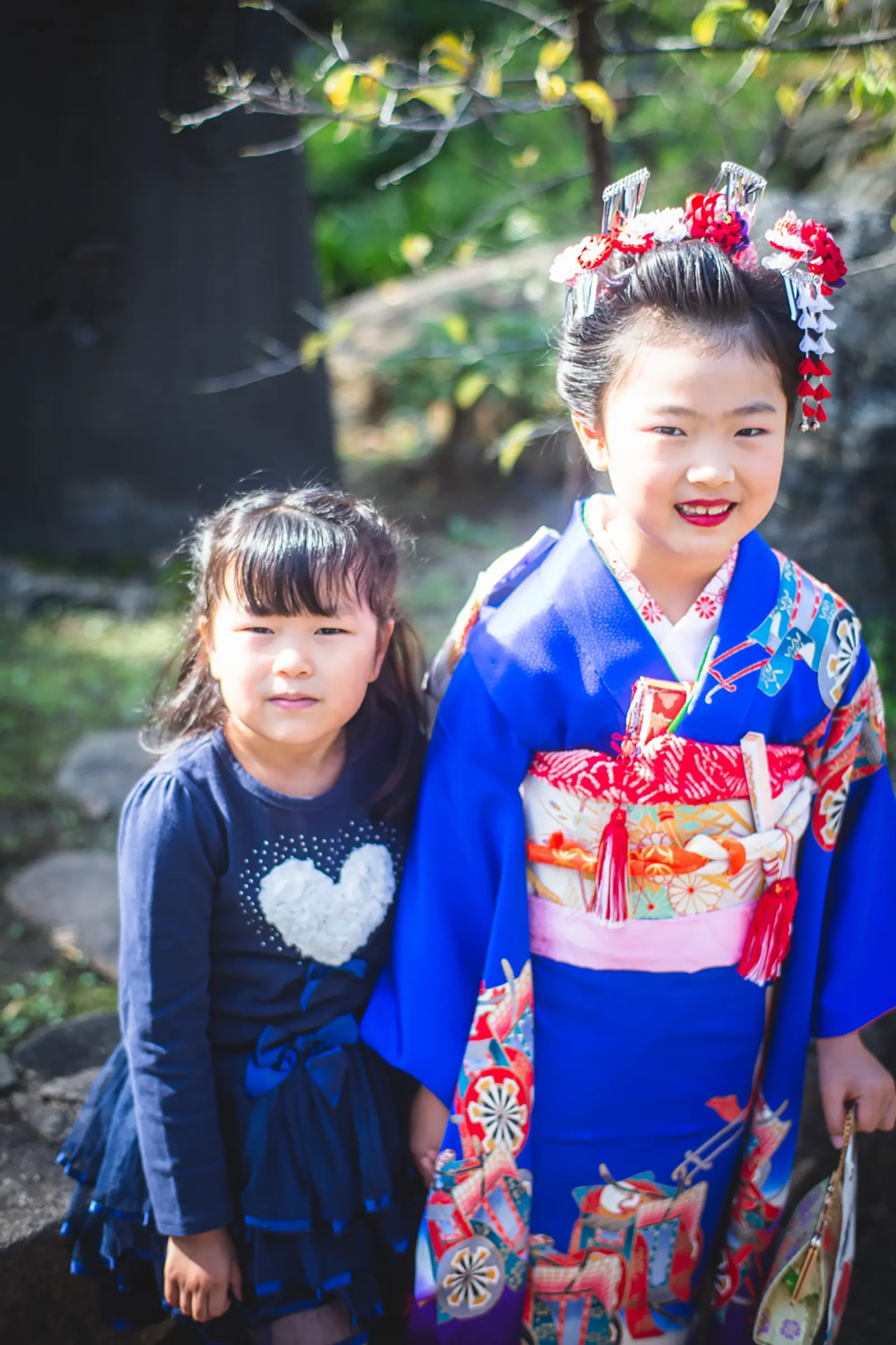 四つ身の7歳の女の子と洋服の妹が寄り添う七五三の記念写真（湯島天神・東京）